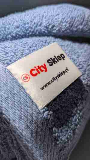 Detal bawełnianego ręcznika City Sklep w kolorze jeans – zbliżenie metki i pętelkowej faktury